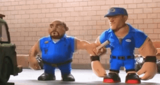 two toy men in blue uniforms are standing next to each other .