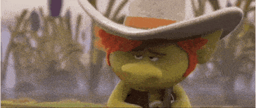 a troll wearing a cowboy hat is holding a gun .