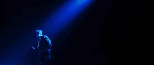 a person is standing in front of a blue light that says ' i 'm ' on it