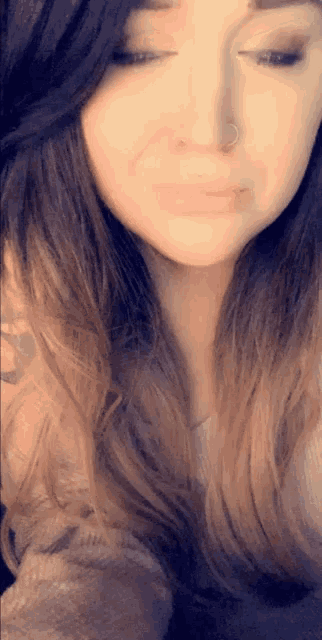 a woman with long hair and a nose ring