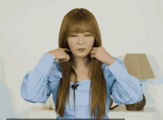 a woman in a blue shirt with a microphone on her neck