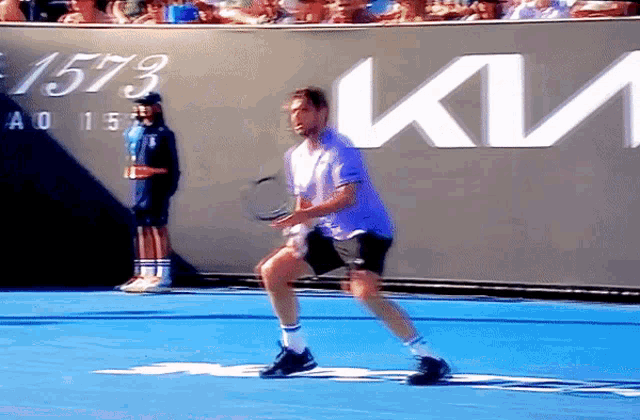 a man is playing tennis in front of a wall that says 1573
