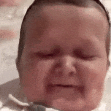 a close up of a baby 's face with his eyes closed .