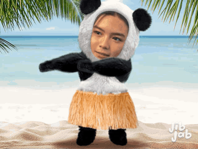 a girl wearing a panda costume and a hula skirt on the beach