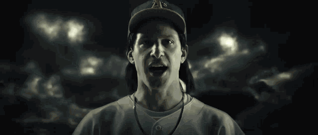 a baseball player wearing a green a's hat is covered in smoke