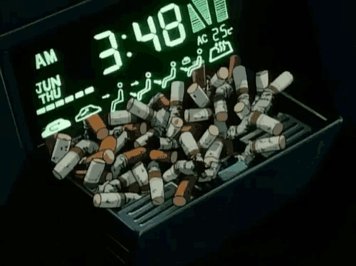 a pile of cigarettes sits in front of a digital clock that says 3:48