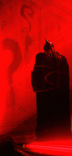 a silhouette of batman is against a red wall