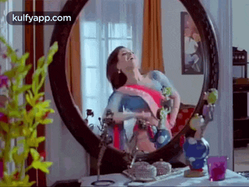 a woman is standing in front of a mirror .