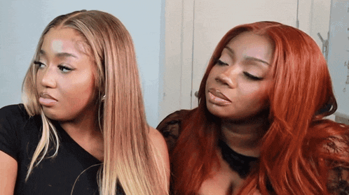 two women with long red hair are looking at each other