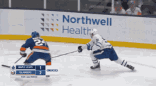 two hockey players are playing in front of a northwell health banner