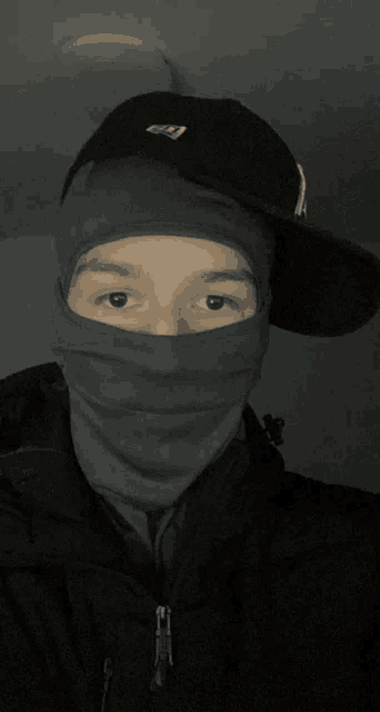 a man wearing a mask and a hat with the letter g on the front