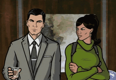 a man in a suit and tie and a woman in a green sweater are standing next to each other .