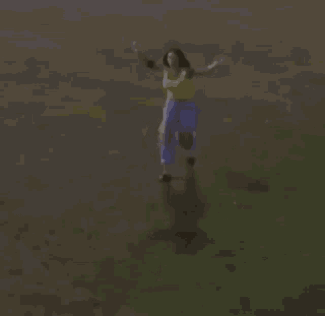 a woman in a yellow top and blue pants is running on a field .