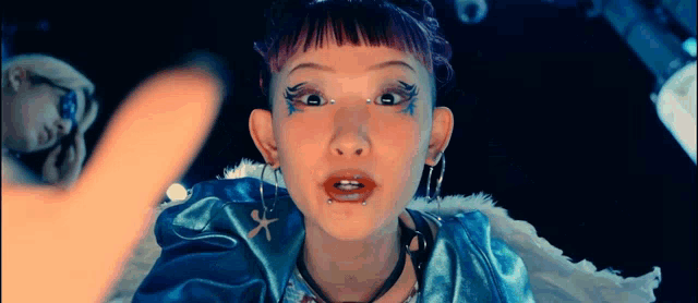 a girl with piercings in her ears is wearing a blue outfit