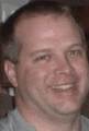 a close up of a man 's face with a blurred background smiling .
