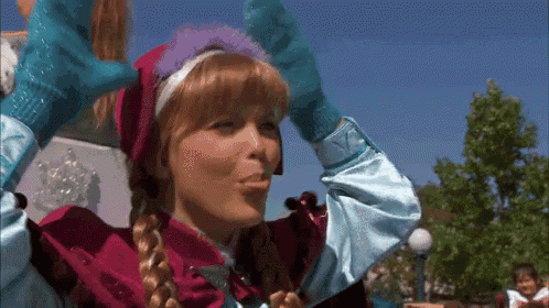 a woman dressed as anna from frozen is blowing a kiss