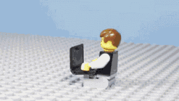 a lego figure is standing on a white brick surface holding a book
