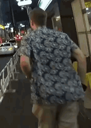 a man in a blue shirt and shorts is running down a sidewalk