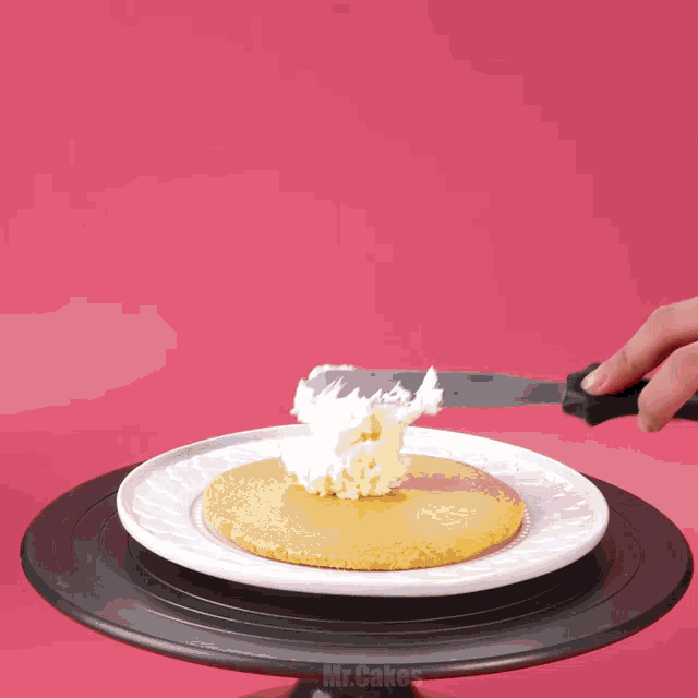 a person is sprinkling powdered sugar on a cookie on a plate that says mr.cakes