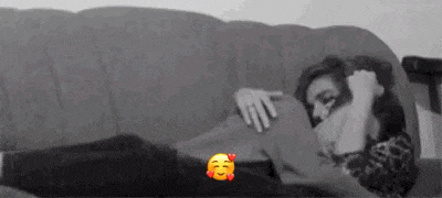 a black and white photo of a woman laying on a couch .