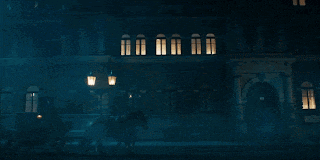 a dark building with a lot of windows and a street light in front of it