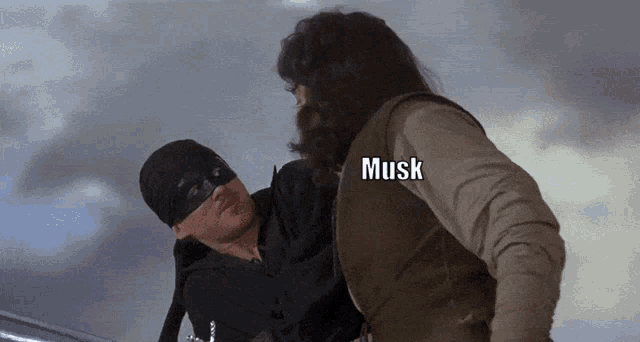 a man in a mask is being held by another man with musk written on the back