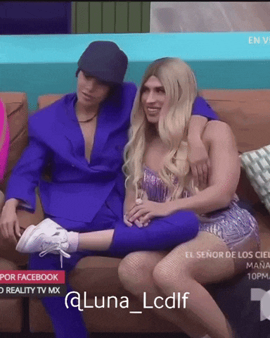 a woman in a purple dress sits on a couch with a man in a suit