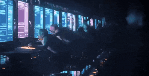 a group of people are sitting in front of computer monitors .