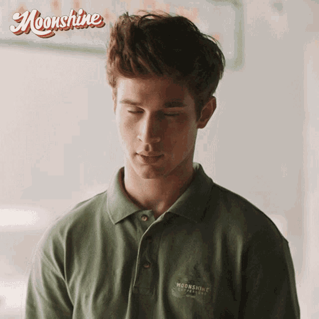 a man wearing a green shirt that says moonshine