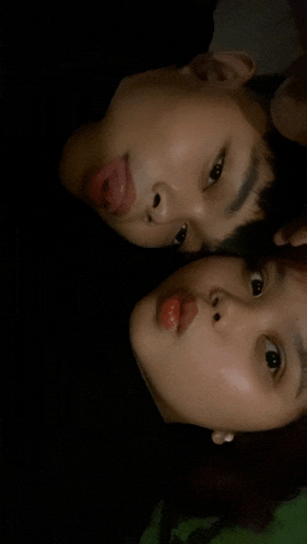 a boy and a girl are laying face to face
