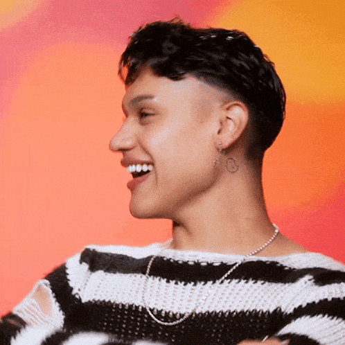 a man wearing a black and white striped sweater is smiling