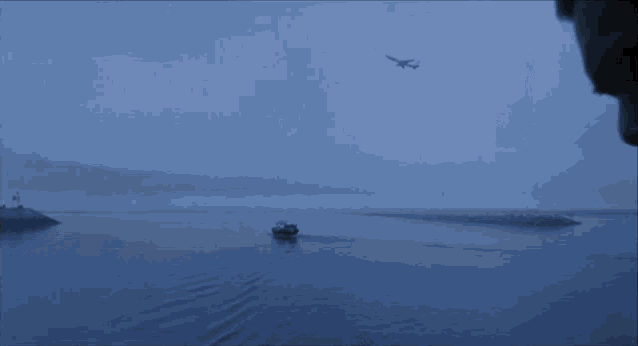 a man smoking a cigarette in front of a body of water