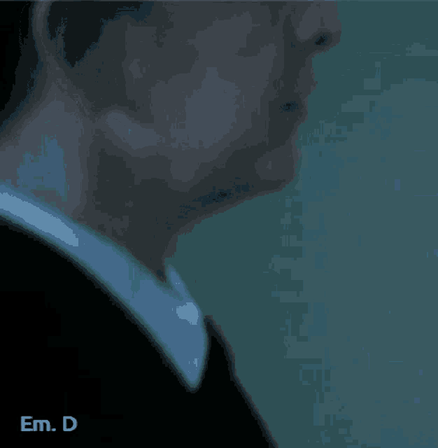 a close up of a man 's face with the words em. d. below him