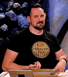a man with a beard wears a black shirt that says ' stout-jam ' on it