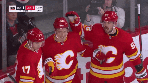 a group of hockey players wearing red jerseys with a c on them