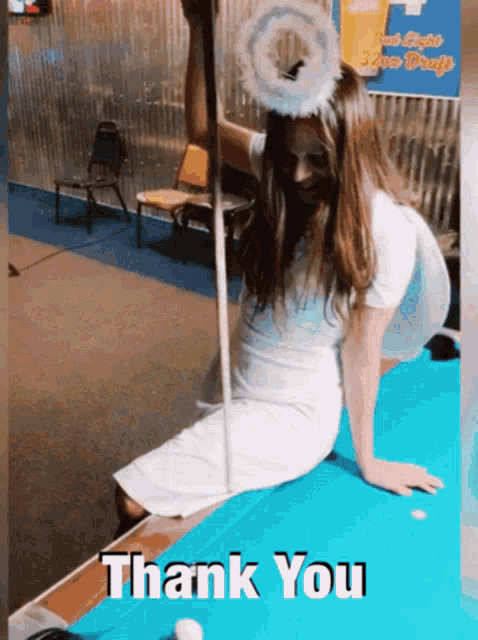 a woman dressed as an angel is sitting on a pool table with the words thank you written below her