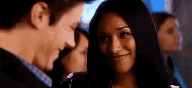 a man and a woman are smiling at each other while standing next to each other .