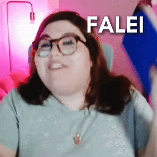 a woman wearing glasses is sitting in front of a pink wall with the word falei written on it .