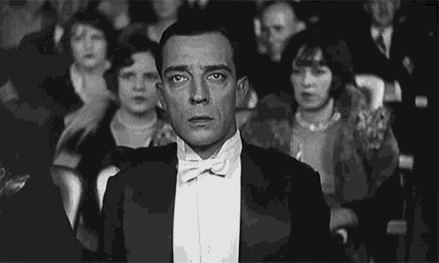 a black and white photo of a man in a tuxedo and bow tie