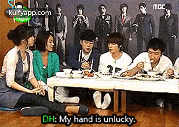 a group of people are sitting at a table eating food and talking .