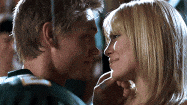 a man and a woman are looking at each other and the man is wearing a green jersey