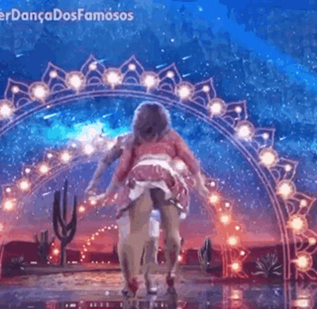 a man is carrying a woman on his shoulders while they dance on a stage .