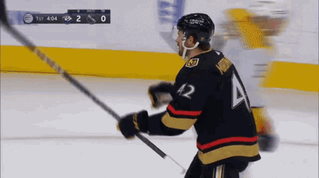 a hockey player with the number 42 on his jersey stands on the ice