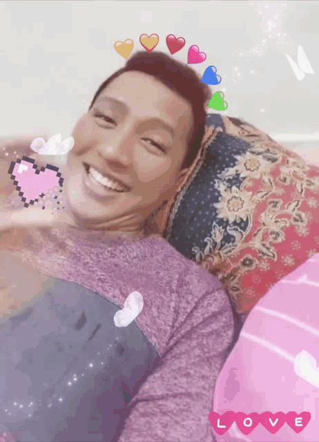 a man is laying on a bed with hearts on his head and the word love underneath