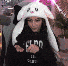 a woman wearing a bunny hat and a sweater that says california