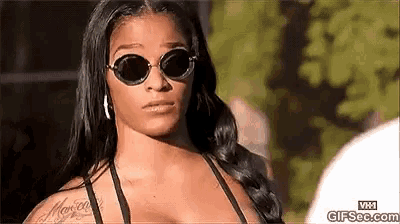 a woman wearing sunglasses and a bikini top has a tattoo on her arm that says ' marie '