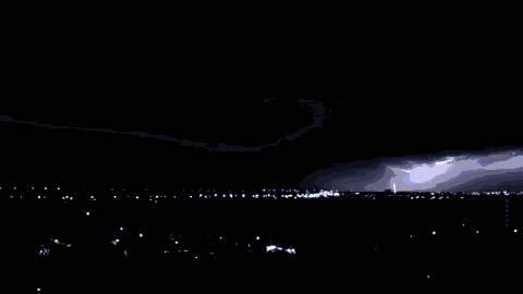 a lightning bolt is visible in the night sky above a city