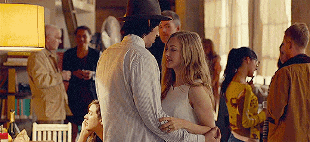 a man and a woman are dancing in a room with a crowd of people .