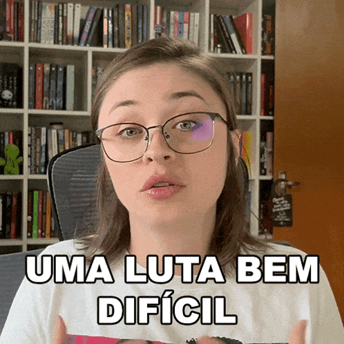 a woman wearing glasses says uma luta bem dificil in front of a bookshelf