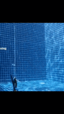 a swimming pool with a blue tile wall and the word diving on the bottom